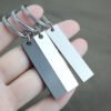 Technical dimensions of a flat rectangle metal bar keychain showing 45mm by 10mm pendant and 28mm key ring size for B2B supplier catalog.Can be used for laser engraving custom text.