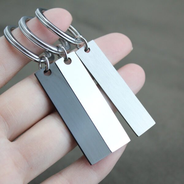 Technical dimensions of a flat rectangle metal bar keychain showing 45mm by 10mm pendant and 28mm key ring size for B2B supplier catalog.Can be used for laser engraving custom text.