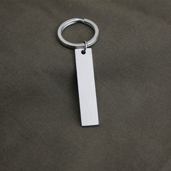 Technical dimensions of a flat rectangle metal bar keychain showing 45mm by 10mm pendant and 28mm key ring size for B2B supplier catalog.Can be used for laser engraving custom text.