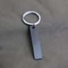 Technical dimensions of a flat rectangle metal bar keychain showing 45mm by 10mm pendant and 28mm key ring size for B2B supplier catalog.Can be used for laser engraving custom text.