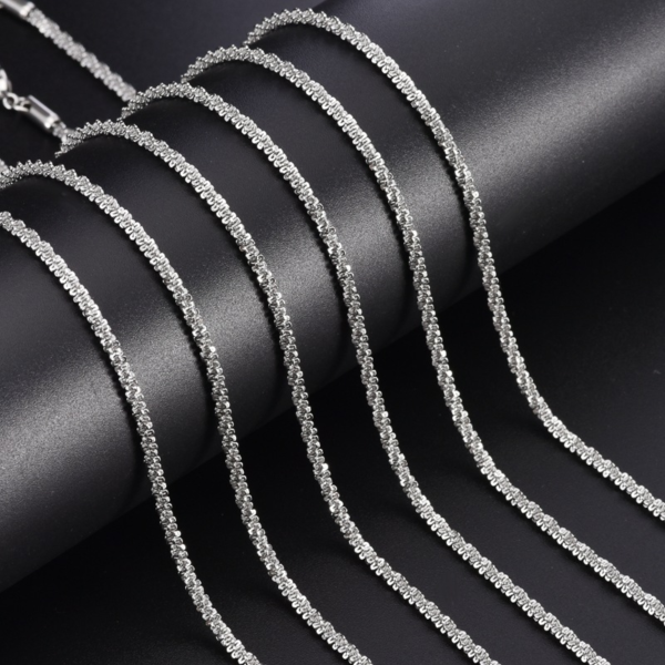 97(`(DRX~TSUYAE11YQ8_MQ Wholesale finished silver stainless steel sparkle chains with multi-angle reflective surfaces arranged on a dark background for jewelry wholesale catalog.