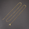 A gold stainless steel cable chain with a lobster clasp and jump ring, placed on a black background.