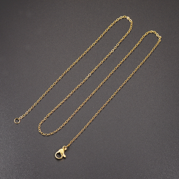 A gold stainless steel cable chain with a lobster clasp and jump ring, placed on a black background.