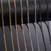 Stainless steel cross chains in silver, gold, black, and rose gold, neatly arranged against a black background.