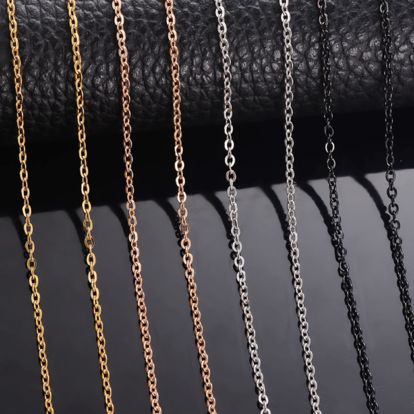 Stainless steel cross chains in silver, gold, black, and rose gold, neatly arranged against a black background.