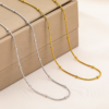 TCUBO%Y$~(CEZ`S0XX@MO Wholesale finished silver and 18K gold plated stainless steel satellite snake chain necklaces displayed elegantly side by side over a luxury jewelry box.