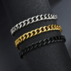 Wholesale men's stainless steel Cuban chain bracelets wrapped around a dark cylinder display in silver, 18K gold, and PVD black finishes.