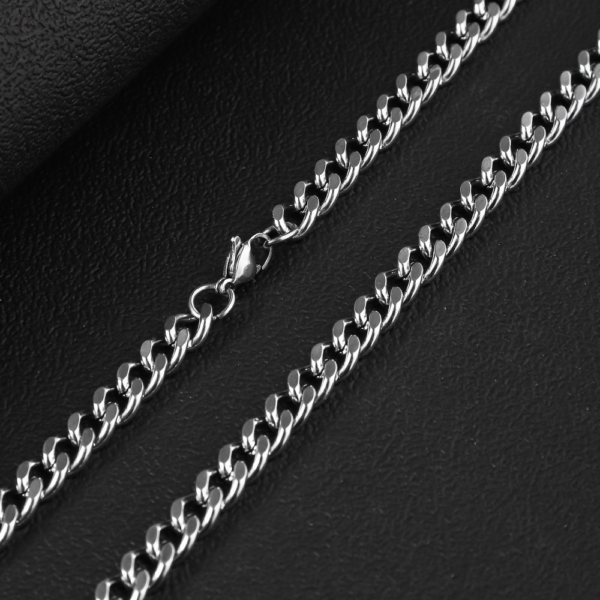 Detailed view of a high-quality finished silver stainless steel curb chain necklace with a secure lobster clasp on a dark textured background for B2B supplier.