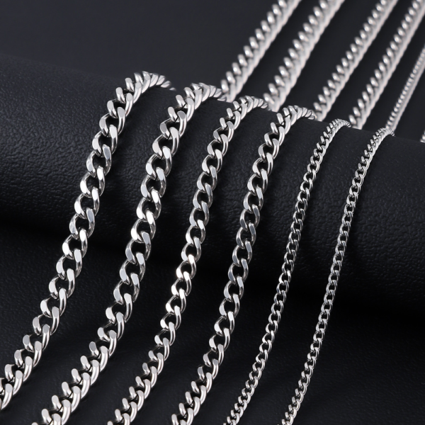 A multi-size catalog photo of wholesale silver stainless steel curb chain necklaces arranged neatly from delicate thin to bold chunky widths.