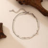 双层不锈钢扁蛇骨链+夹珠圆蛇链 (2) A finished silver stainless steel double layer flat snake and bead chain bracelet layout with a lobster clasp for B2B supplier shop.