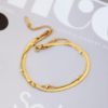 双层不锈钢扁蛇骨链+夹珠圆蛇链 (4) Close-up of a luxury 18K gold plated double layer stainless steel herringbone and round bead chain necklace on a jewelry box for bulk catalog.