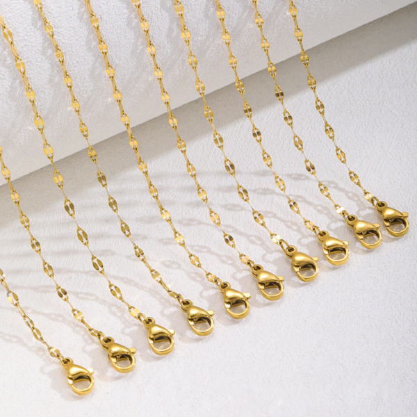 Multiple finished gold stainless steel lip chain necklaces arranged side by side showing the premium lobster clasps for volume wholesale sourcing.