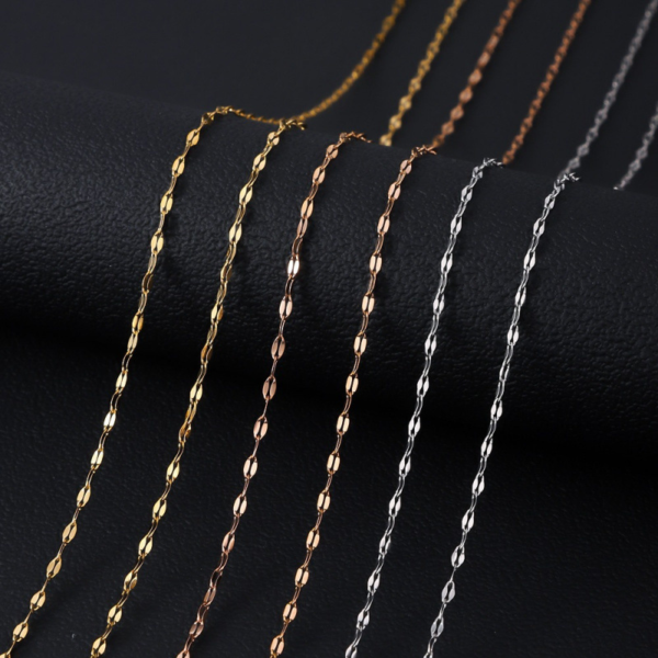 Parallel layout of silver, gold, and rose gold finished stainless steel sequin necklaces over a black backdrop for B2B supplier web site.