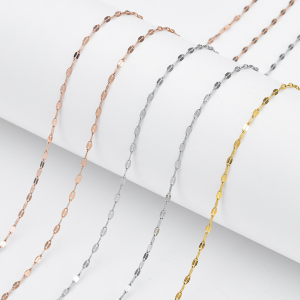 Finished stainless steel shimmering sequin chains in gold, steel silver, and rose gold finishes neatly draped over a white cylindrical column.