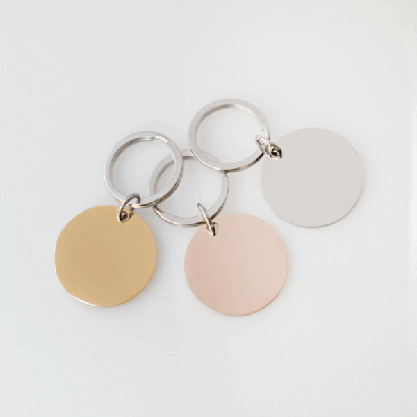 圆形钥匙扣 (2) A bundle of wholesale custom gold, silver, and rose gold flat round metal tag keyrings ready for laser engraving on a clean backdrop.