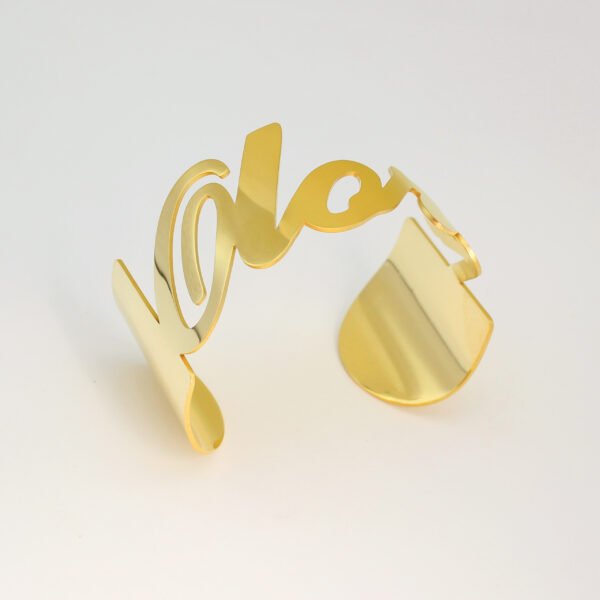 大字母手镯_0006_图层 1 Personalized cursive nameplate open cuff bracelet in luxury gold stainless steel standing flat on a white surface for custom jewelry store.