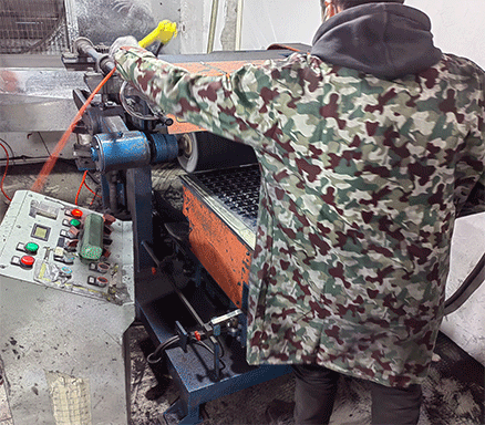 A worker is operating a stainless steel jewelry polishing machine.