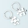 拼图钥匙扣 (1) Two silver stainless steel customized puzzle key rings interlocking smoothly together on a clean backdrop for promotional gift sourcing.