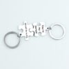 拼图钥匙扣 (12) Wholesale finished silver stainless steel interlocking puzzle piece couple keychains engraved with "You're my person" on a clean background.