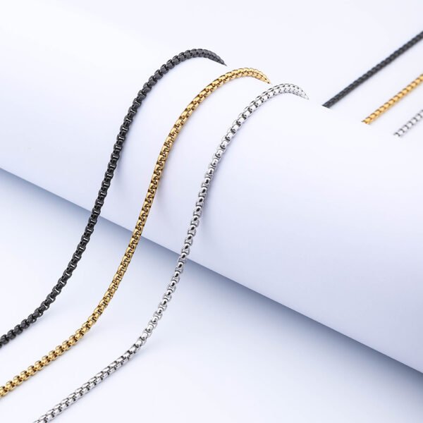 Steel-tone, gold-tone, and black box chains featuring lobster clasps are displayed in a straight line against a white background, allowing B2B buyers to compare the options and examine the details.