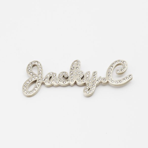 满钻字母胸针 (4) An isolated view of a finished silver stainless steel personalized script rhinestone name brooch pin flatly laid out on a clean white background.