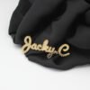 满钻字母胸针 (6) A heavy-duty custom 18K gold plated cursive letter name brooch pinned securely on a black silk cloth highlighting the crystal pave setting.