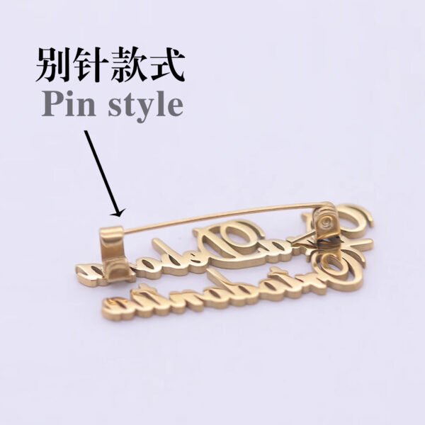 B2B catalog photo showing the back of a wholesale custom gold stainless steel name brooch pin showcasing the sturdy long pin style backing mechanism.