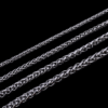 Wholesale finished silver stainless steel wheat spiga chain necklaces in multi-size widths from 2mm to 6mm arranged neatly on a black background.