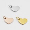 16×12偏孔小心形_0000_图层 8 Wholesale blank heart-shaped metal stamping tags in silver, rose gold, and gold finishes ready for laser engraving on a clean backdrop.