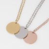 20圆牌和十字链 01 Close-up view of gold, silver, and rose gold stainless steel round charm pendants side by side highlighting the high mirror polish finish.