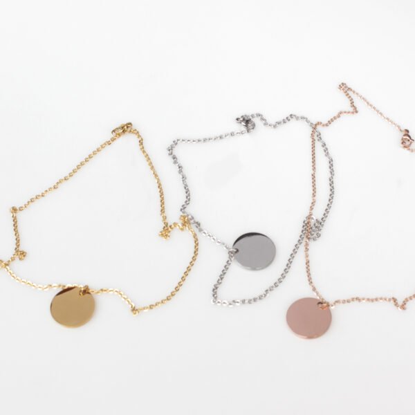 20圆牌和十字链 03 Multiple finished silver, gold, and rose gold round locket necklaces coiled into compact circles next to their chains for B2B supplier shop.