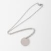 20圆牌和十字链 08 An isolated view of a finished silver stainless steel minimalist round coin pendant necklace flatly laid on a clean white backdrop for B2B catalog.