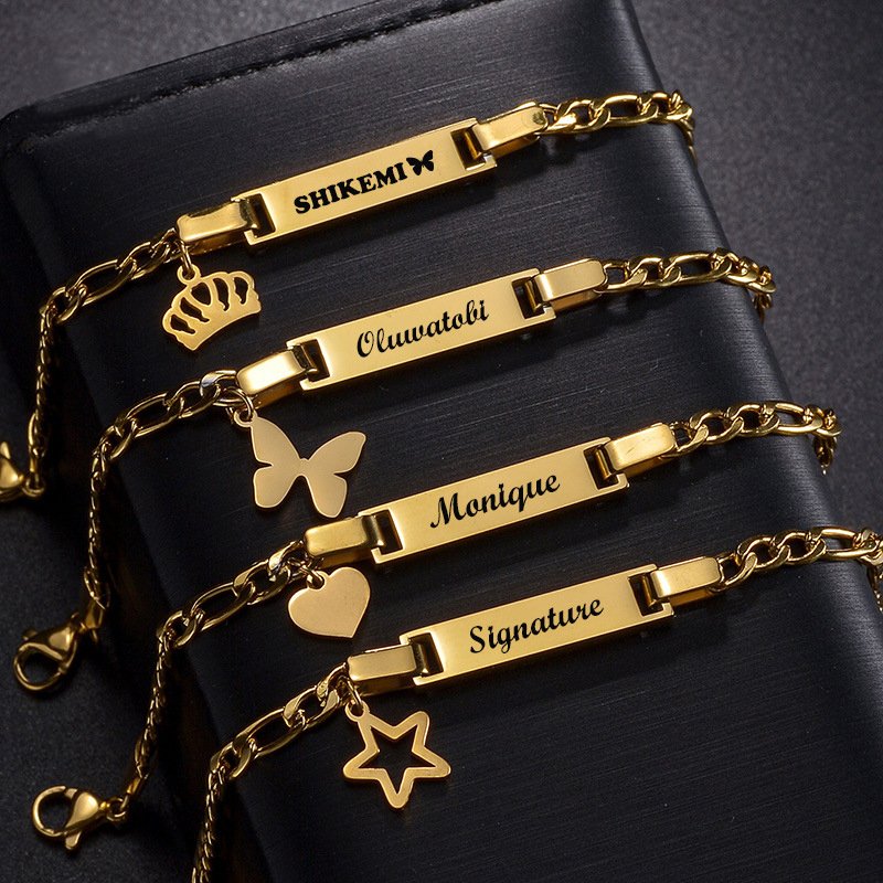 Wholesale custom gold stainless steel kids ID bracelets engraved with names Shikemi, Oluwatobi, Monique, and Signature with matching heart and star charms.
