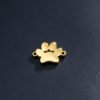 A high-polish gold stainless steel animal paw connector charm displaying intense metallic reflection on a dark textured background.