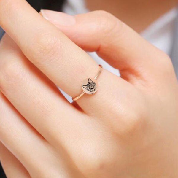 圆形戒指定制_0003_dddddddd Model wearing a customized rose gold plated stainless steel disc ring laser etched with a highly detailed fine-line cat portrait on a finger.