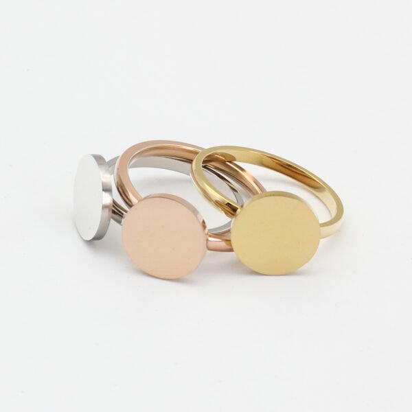 圆牌戒指_0002_图层 7 Three plain, round rings—in silver, gold, and rose gold—are arranged in an overlapping pattern on a solid-colored background, showcasing their exquisite craftsmanship.