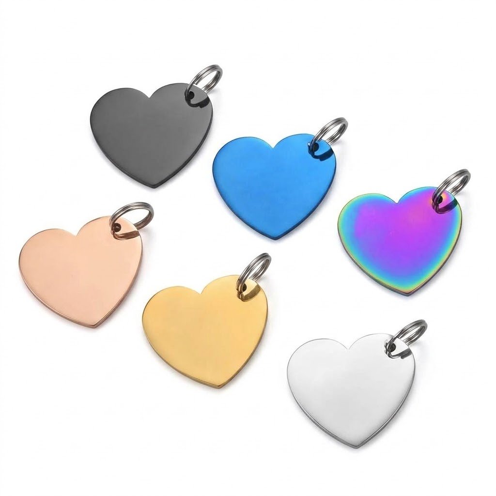 Six heart-shaped metal engraving blank tags shown in black, blue, rainbow, rose gold, gold, and silver finishes, neatly arranged on a clean white background for catalog display.