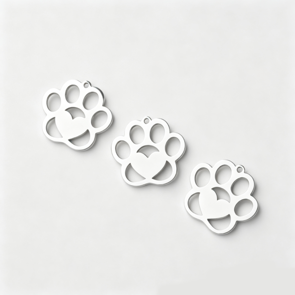 Three blank finished silver stainless steel hollow paw shape charms laid flat in a diagonal row on a clean white background for B2B shop catalog.