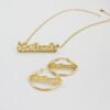 描边项链耳环套装_0002_图层 11 A blank finished 18K gold plated stainless steel personalized 2-layer cursive name necklace and hoop earrings set spelling "Anikeade" on a white background.