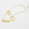 描边项链耳环套装_0003_图层 10 A blank finished 18K gold plated stainless steel personalized 2-layer cursive name necklace and hoop earrings set spelling "Anikeade" on a white background.