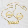描边项链耳环套装_0005_图层 2 A blank finished 18K gold plated stainless steel personalized 2-layer cursive name necklace and hoop earrings set spelling "Anikeade" on a white background.