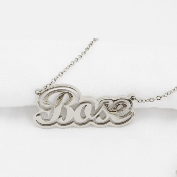 描边项链耳环套装_0009_IMG_6054 Macro close-up view of a finished silver stainless steel 3D layered cursive name pendant "Bose" to showcase the smooth laser-cut edges and high mirror polish.