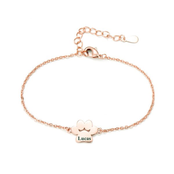 A minimalist rose gold-plated stainless steel bracelet with a mirror-polished finish, featuring a paw-print charm and a secure lobster clasp.