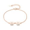A minimalist rose gold-plated stainless steel bracelet with a mirror-polished finish, featuring two interlocking paw-print charms and a secure lobster clasp.