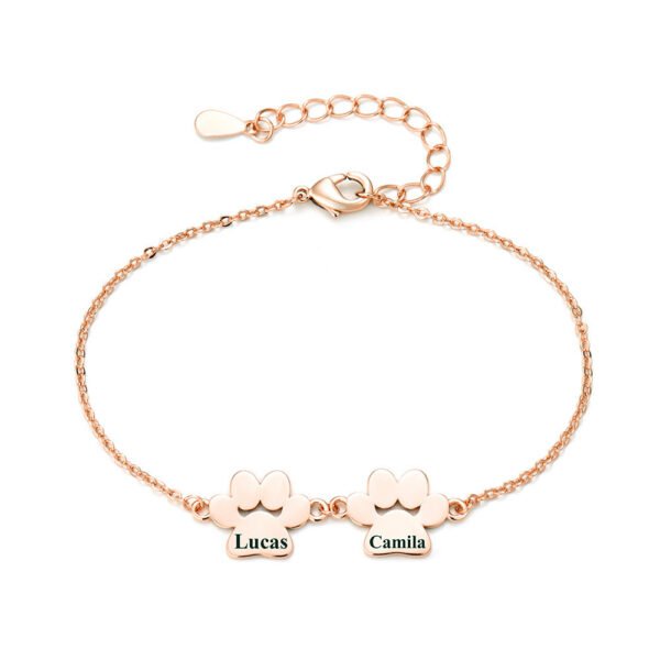 A minimalist rose gold-plated stainless steel bracelet with a mirror-polished finish, featuring two interlocking paw-print charms and a secure lobster clasp.
