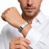 Model wearing a sleek silver stainless steel watch strap style men's ID bracelet to showcase its dapper masculine aesthetic for custom jewelry store layout.