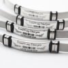 网手环 腐蚀抹油DAD_0002_图层 4 Close-up view of multiple silver stainless steel watch band ID bracelets highlighting the deep embossed black ink-filled text and smooth side rubber rings.