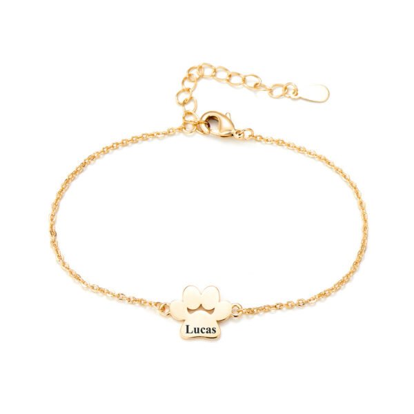 A minimalist gold-tone stainless steel bracelet with a mirror-polished finish, featuring a paw-print charm and a secure lobster clasp.