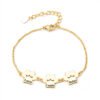 A minimalist gold stainless steel bracelet with a mirror-polished finish, featuring three interconnected paw-print charms and a secure lobster clasp.