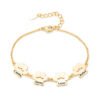 A minimalist gold stainless steel bracelet with a mirror-polished finish, featuring three interconnected paw-print charms and a secure lobster clasp.